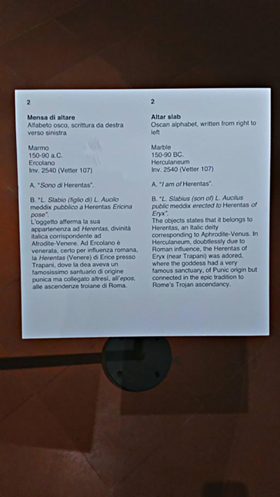 Herculaneum, information card from Naples Archaeological Museum, inv. 2540 (Vetter 107).
Photo courtesy of Giuseppe Ciaramella, June 2017.
According to Guidobaldi-
“La prima sistemazione dell’area risale probabilmente all’età augustea, ma già nell’età preromana, in forme che non sono al momento note, doveva essere qui praticato almeno il culto di Venere, come testimonia l’unica iscrizione in lingua osca restituita dalla citta, quella sull’altare della dea Herentas Erycina
(Herentas è il corrispettivo osco di Venere), fatto fare da Luvkis Slabis Aukil, sommo magistrato del periodo sannitico (meddiss tuvtiks).
Gli edifici di culto furono profondamente restaurati dopo uno dei terremoti che sconvolsero l’area vesuviana nei 17 anni precedenti l’eruzione.”
See Guidobaldi, M.P. (2009). Ercolano, guida agli scavi. Electa Napoli, (p.37).
(trans:
The first arrangement of the area probably dates back to the Augustan age, but already in the pre-Roman age, in a form that is not currently known, the cult of Venus, at least, would have been practised here, as evidenced by the only inscription in the Oscan language returned from the city, the one on the altar of the goddess Herentas Erycina (Herentas was the Oscan equivalent of Venus), made by Luvkis Slabis Aukil, high Magistrate of the Samnite period (meddis tuvtiks).
The buildings of the cult were extensively restored after one of the earthquakes that devastated the Vesuvian area in the 17 years preceding the eruption.”)